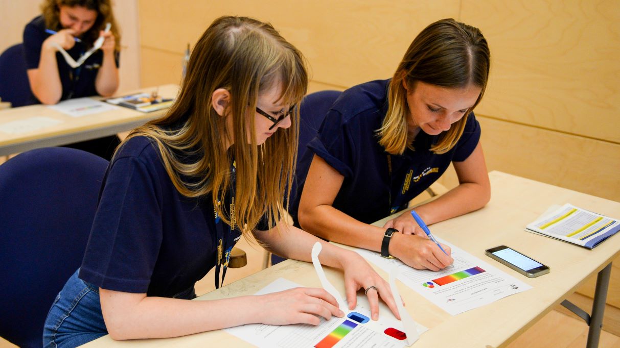 Frauen arbeiten gemeinsam an einem Übungsblatt