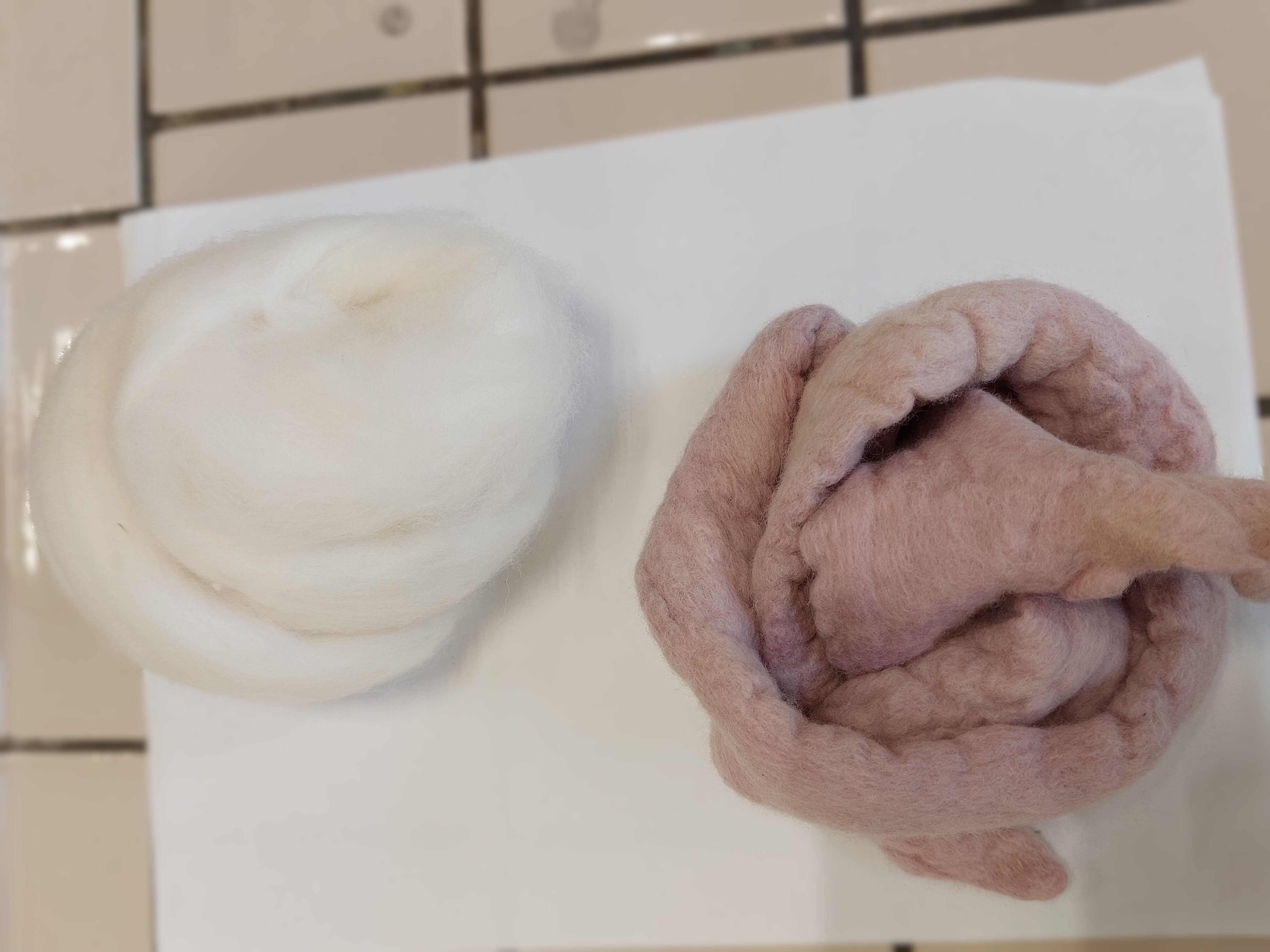 etwas weiße, ungefärbte Wolle neben etwas hellviolett gefärbte Wolle