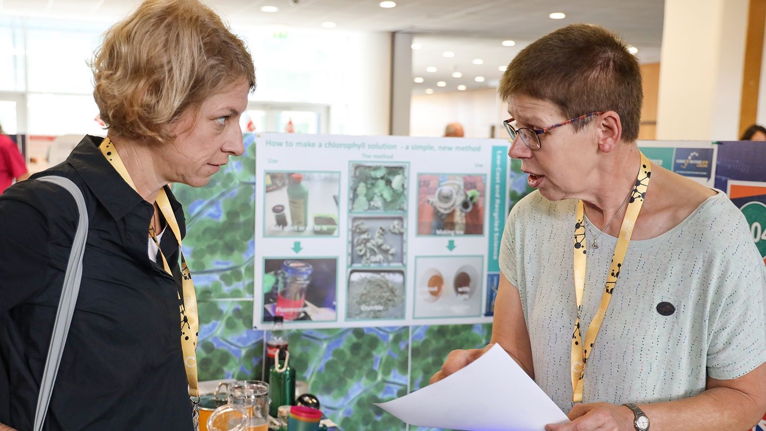 Zwei Frauen sprechen miteinander, eine erklärt der anderen ihr Projekt 