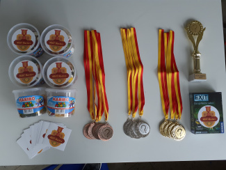 Preise für den Wettbewerb MINT Masters: Süßigkeiten und Sticker für alle Teams, Medallien in Bronze, Silber und Gold, ein Pokal und ein Spiel für das Siegerteam